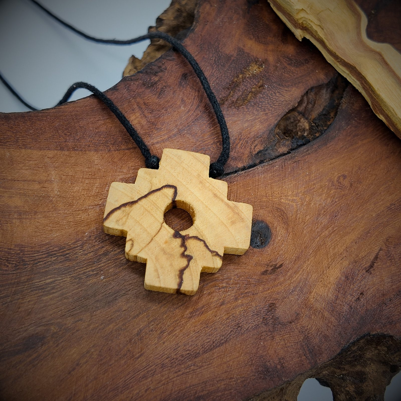 a chakana shaped pendant made of natural palo santo wood that is very fragrant and considered very high frequency in spirituality for cleansing and clearing and attracting good energy