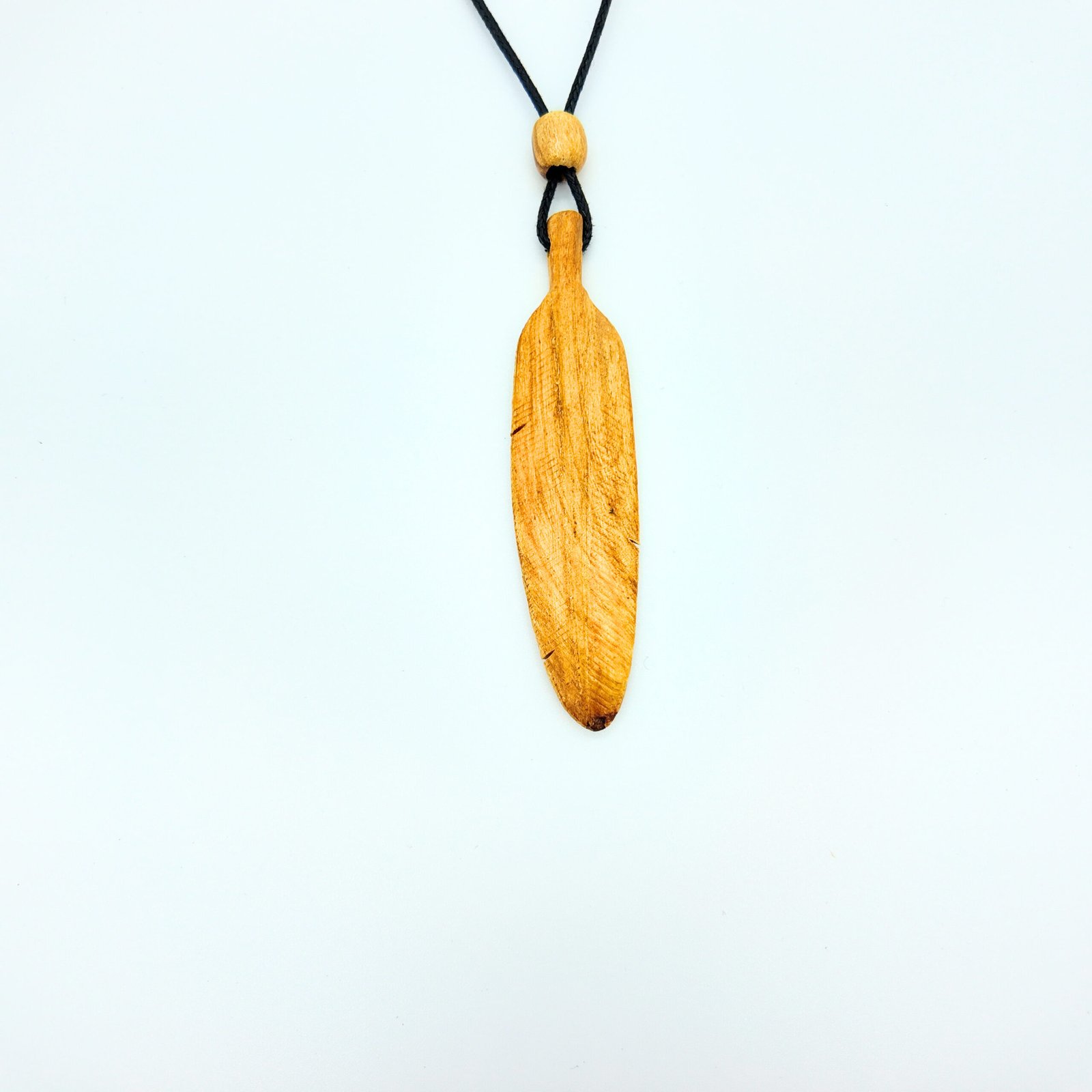 a feather shaped pendant made of natural palo santo wood that is very fragrant and considered very high frequency in spirituality for cleansing and clearing and attracting good energy